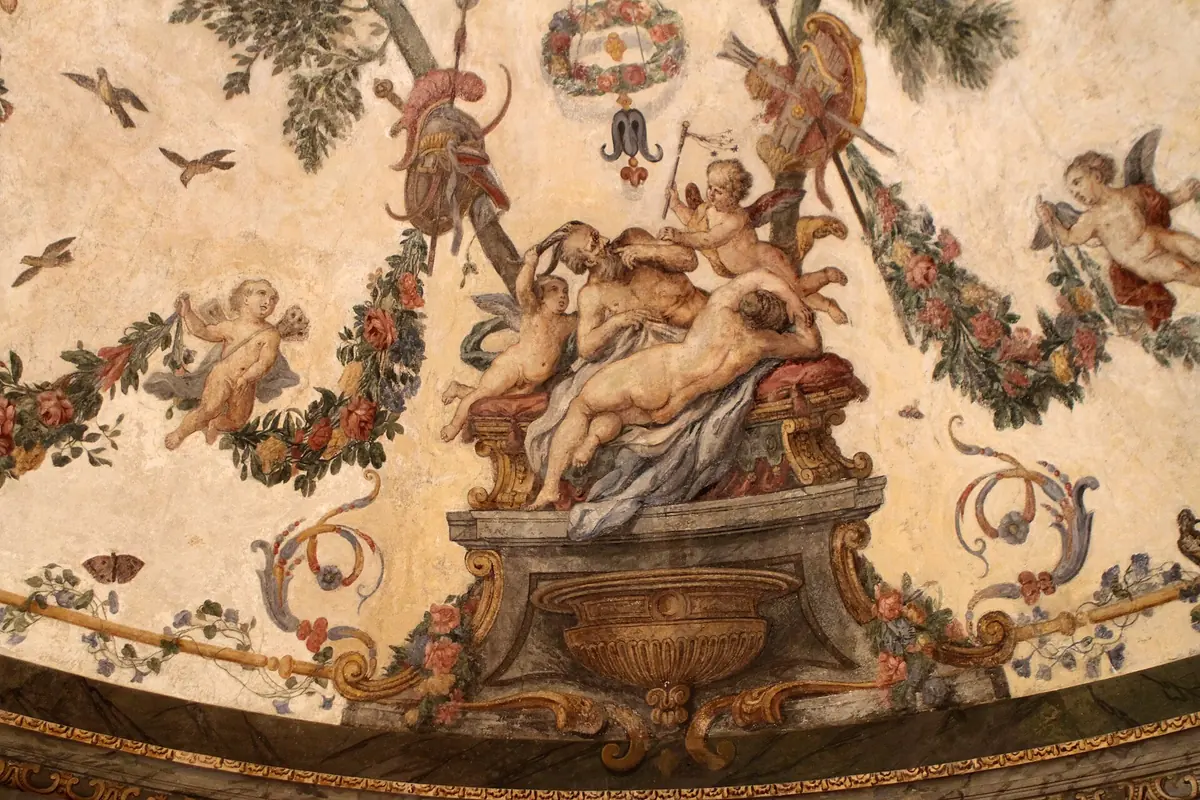 Painted detail of the dome: an old man reclining on a plinth with cherubs, garlands, birds and trophies of arms around a hanging wreath.